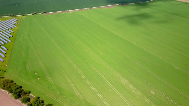 Aerial view of solar power plant in a middle of agriculture landscape.