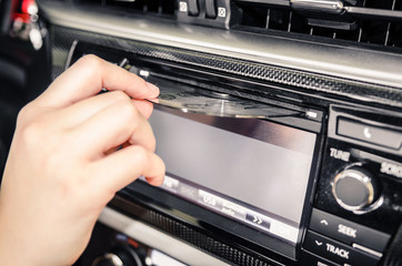 Hand removing a cd from the car radio