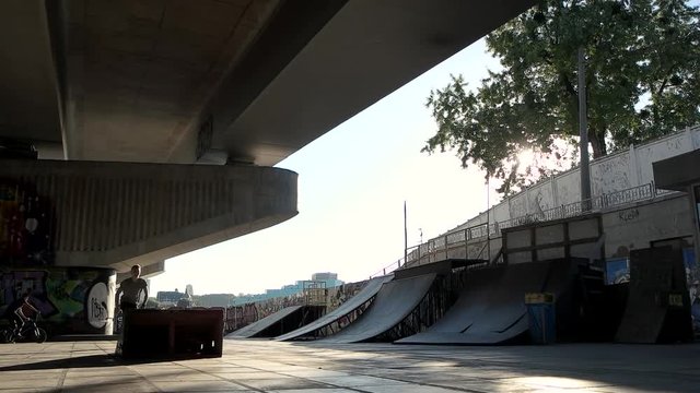 Trick of inline skater, slow-mo. Young rollerblader on urban background. Jump off the ramp.
