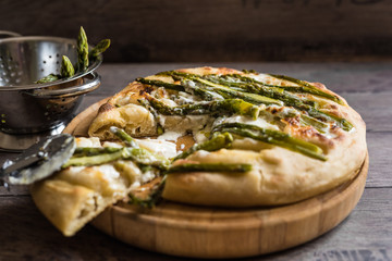 fetta di pizza al formaggio e asparagi; colino con asparagi sullo sfondo