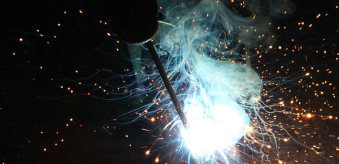 Sparks and jets of smoke when welding - obrazy, fototapety, plakaty