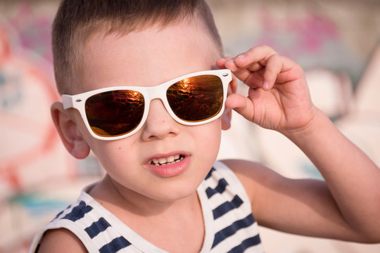 Beautiful little boy in trendy sunglasses in summer