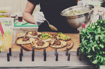 Street vendor hands making taco outdoors