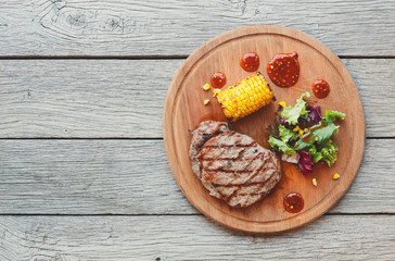 Grilled beef steak closeup on dark wooden table background