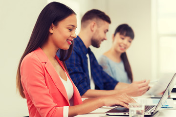 happy african woman over creative team at office