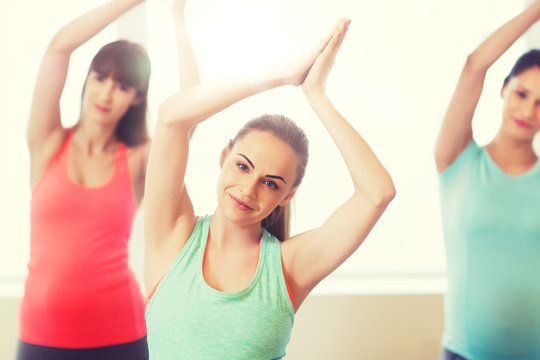 happy pregnant women exercising in gym