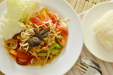 Somtum Thai spicy green papaya and black pickled crab salad eat with sticky rice