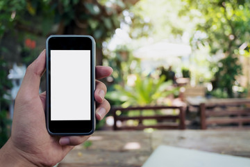 Mockup image of hand holding black mobile phone with blank white screen with green nature background