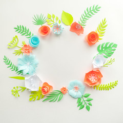 round frame with color paper flowers on the white background. Flat lay. Nature concept