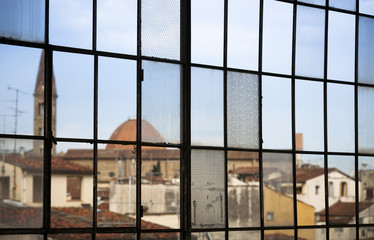 Grid of windows reveals an urban skyline in Florence, Italy