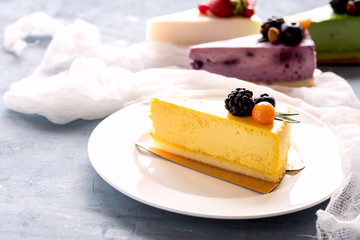 Tasty yellow cheesecake on plate three cheesecakes on background