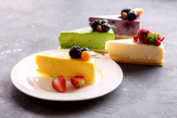 Tasty yellow cheesecake on plate three cheesecakes on background