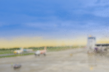Fototapeta na wymiar raindrops on window glass with blurred airplane