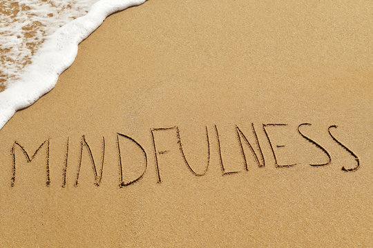 word mindfulness in the sand