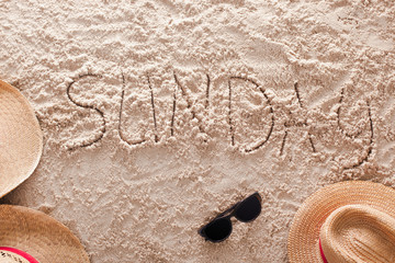 Fototapeta na wymiar Sunday written in a sandy tropical beach