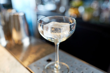 glass with ice cube at cocktail bar
