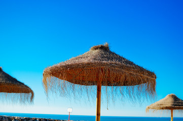 Beach umbrellas and couches on outdoors blue sky background