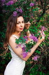  Young girl in complete tranquility and pacification in a beautiful and elegant dress on nature in the spring in the park