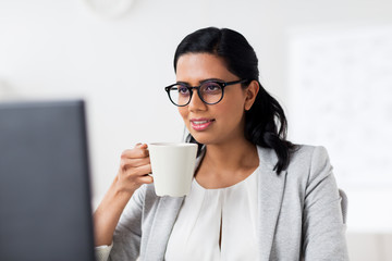 businesswoman drinking coffee at office computer