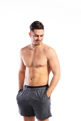 Fototapeta premium Shirtless fitness man, hands in pockets . Studio shot.