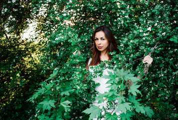 Naklejka premium Young girl in complete tranquility and pacification in a beautiful and elegant dress on nature in the spring in the park