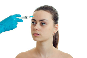 doctor in blue gloves makes injection on the face of the girl