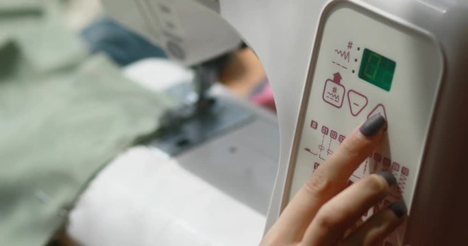 Close-up of woman's hands sewing an overlock automatic machine. Tailor Overlock stitch craft material seam hobby cut macro tool design equipment process clothing work 4k