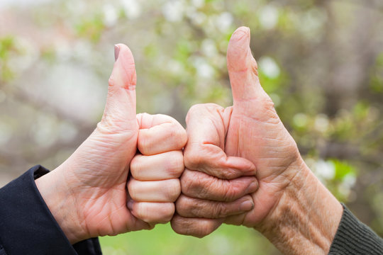 Senior & young woman showing thumbs up