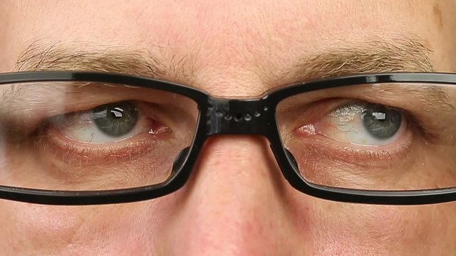 Adult man in eyeglasses extremely close-up view. Thinking looking around. Eye movement side to side. Corner of eyes. Smiling laughing man face w glasses. Think read see down up and side eyes motion