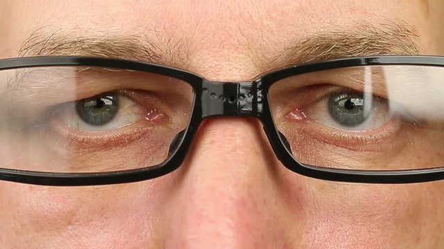 Adult man in eyeglasses extremely close-up view. Thinking looking around. Eye movement side to side. Corner of eyes. Smiling laughing man face w glasses. Think read see down up and side eyes motion