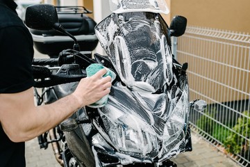 Fototapeta premium Cleaning black touristic motorbike with water