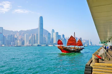 Crédence de cuisine en verre imprimé Hong Kong Vue sur les toits de Hong Kong avec un voilier chinois rouge passant sur le port de Victoria par une journée ensoleillée.