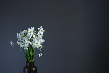 White daffodils in a brown glass jar