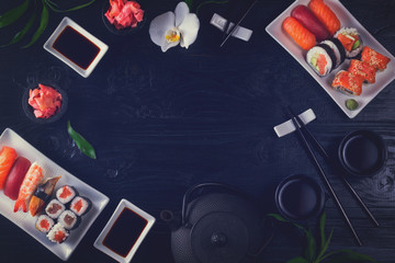 Japanese sushi dish frame on black wooden background with copy space, retro toned