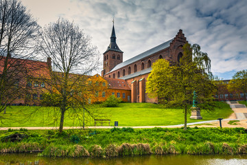 Odense, Denmark - April 29, 2017: Cathedral of Saint Canute and Statue of Hans C Andersen