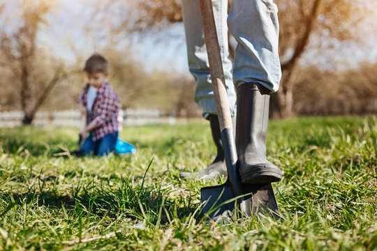 Close up of feet in rubber boots at garden