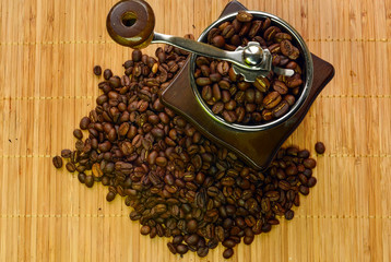 Coffee-grinder with coffee-beans over wooden