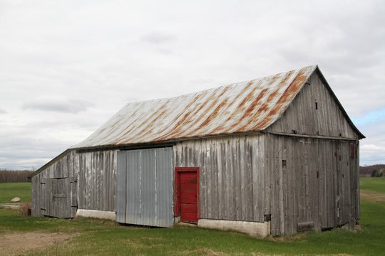 Old abandoned wood  barn with red door