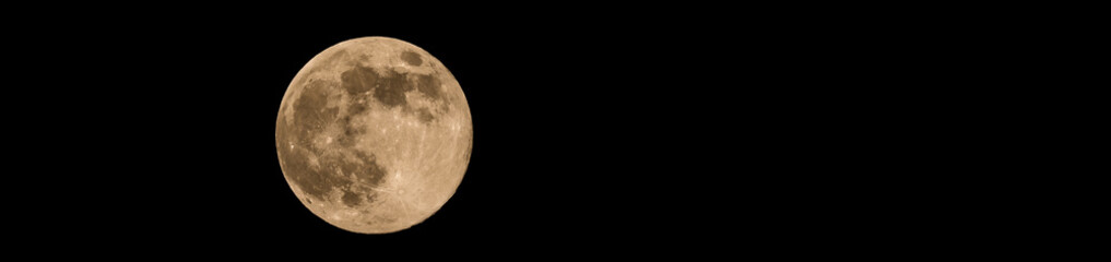Photo of full-moon with soft yellow color an visible craters