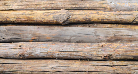 Naklejka premium long old wooden logs folded horizontally close-up