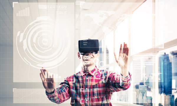 Young man in modern office interior experiencing virtual reality