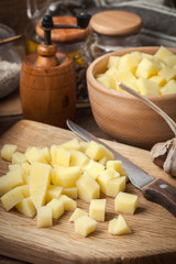 Diced potatoes on a wooden chopping board.
