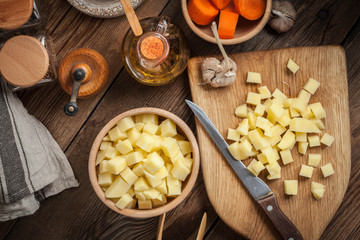 Diced potatoes on a wooden chopping board.