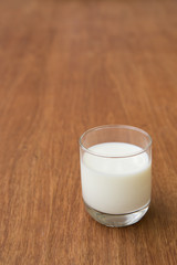 the glass of milk on old wooden table