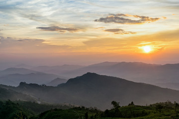 Beautiful landscape nature on mountain with sun cloud fog and bright colors of sky and sunlight during sunset in winter at view point Phu Chi Fa Forest Park in Chiang Rai Province, Thailand