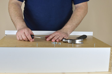 Man's hands on a drawer backside set on working table