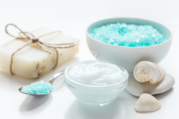 Obraz na płótnie Canvas blue sea salt, soap and body cream on white desk background