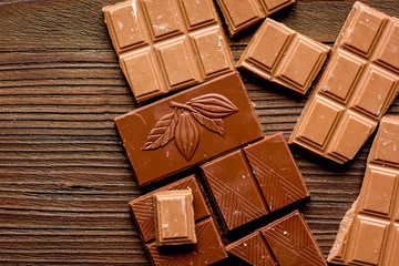 black and milk chocolate bars dark wooden table background top view