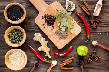 Spices, chili and herbs on wooden kitchen table background top view