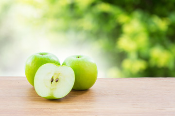 Green apple on wooden vintage table over bokeh background
